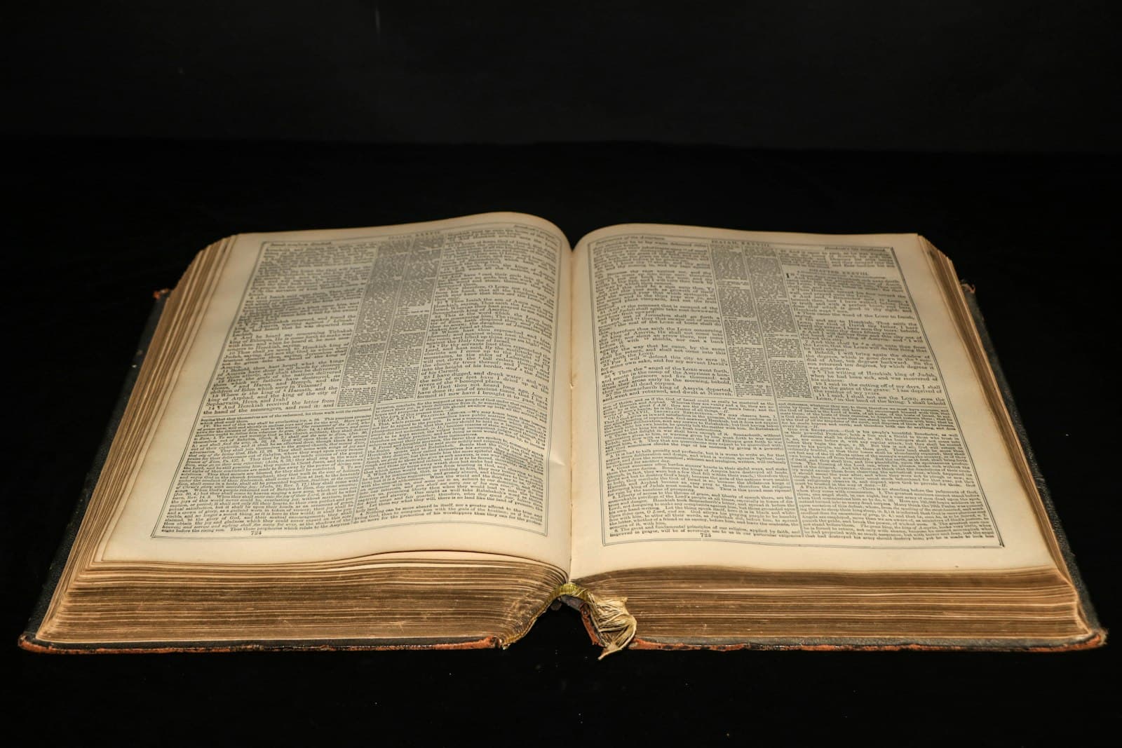 Un gros volume ancien relié, ouvert sur deux pages de texte en colonnes serrées